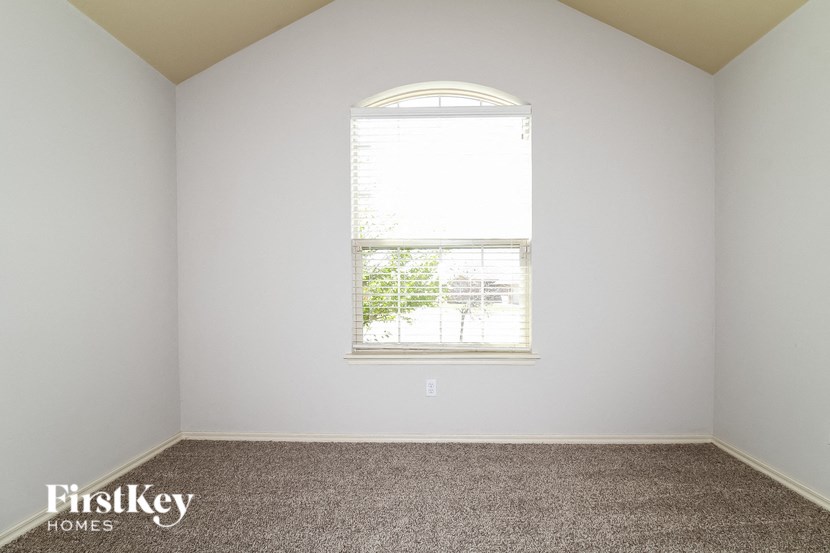 a bedroom with a window and carpeted floor