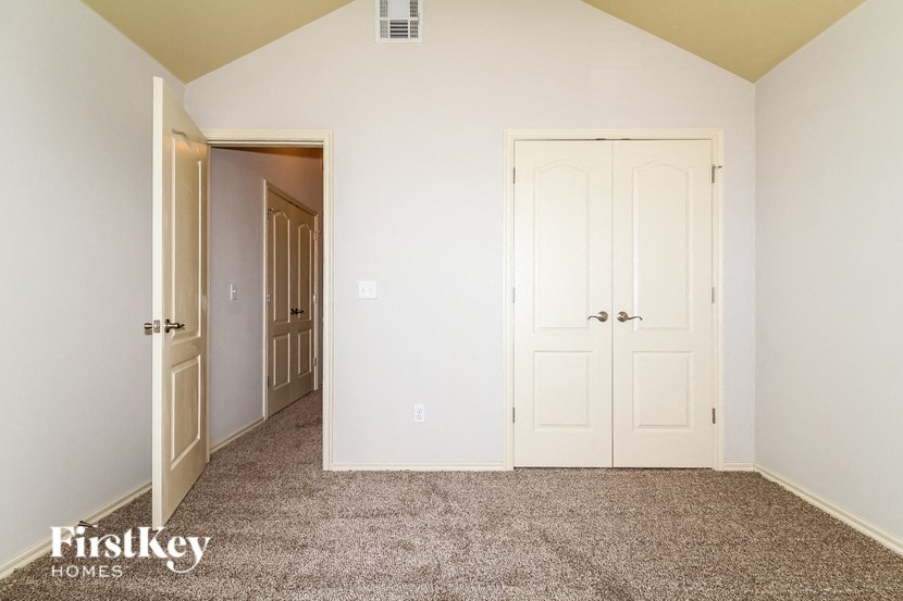 a bedroom with a carpeted floor and white doors