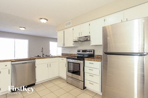 a kitchen with stainless steel appliances and white cabinets