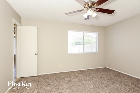 a bedroom with a ceiling fan and a closet