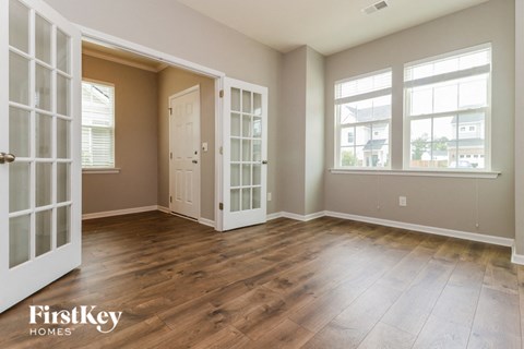 A room with wooden floors and a large window.