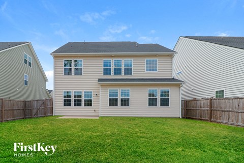 A house with a fence and a grassy yard.