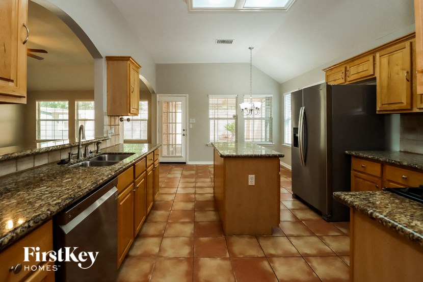 a large kitchen with granite counter tops and stainless steel appliances
