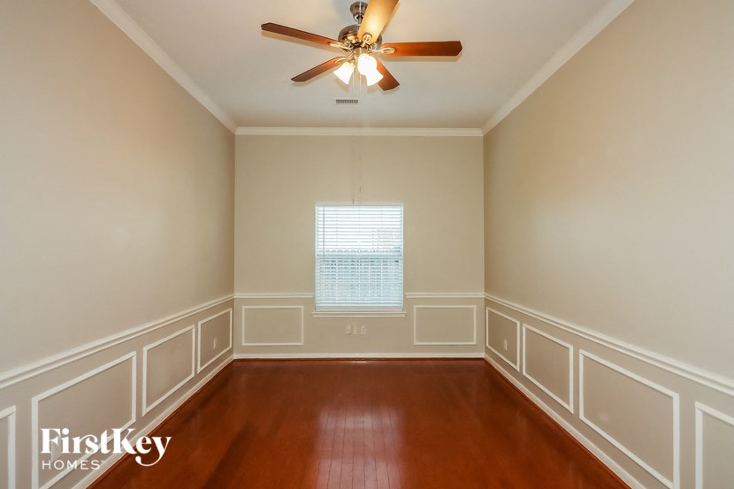 a empty room with wooden floors and a ceiling fan