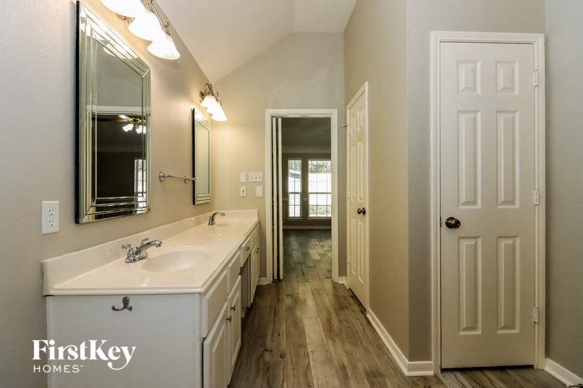 a bathroom with a sink and a mirror and a door