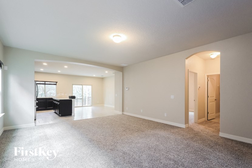 A spacious room with a piano and a carpeted floor.