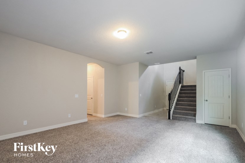 A spacious room with a staircase and a light on the ceiling.