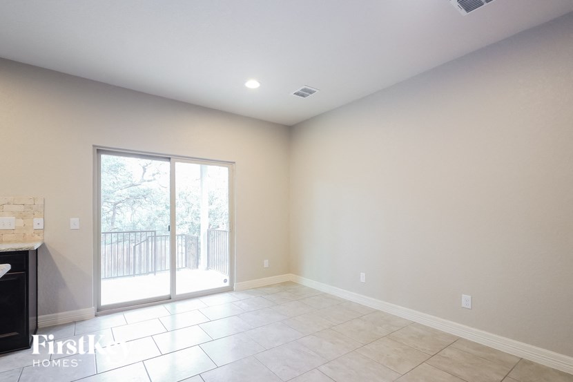 A room with a sliding glass door leading to a balcony.