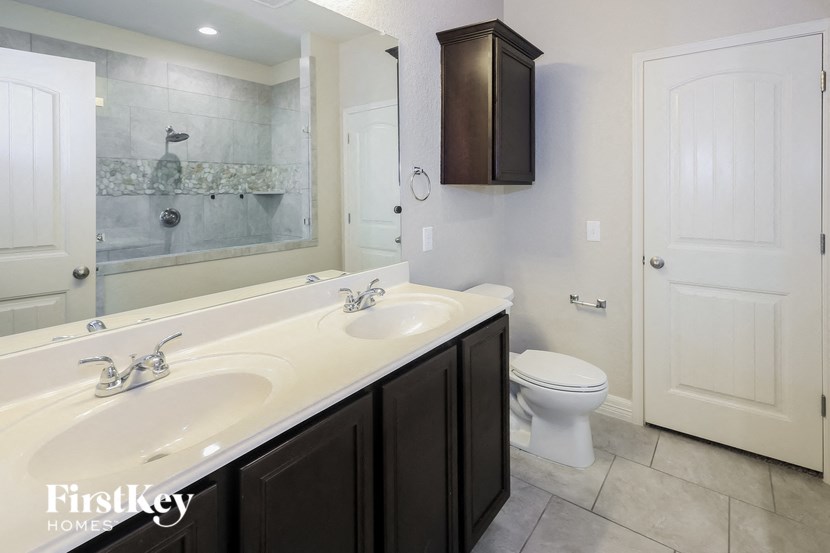 A bathroom with a white sink and a toilet.