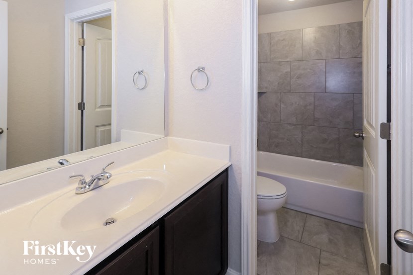 A bathroom with a white sink and a white toilet.