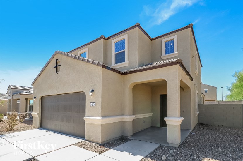 a beige house with a garage door and a blue sky