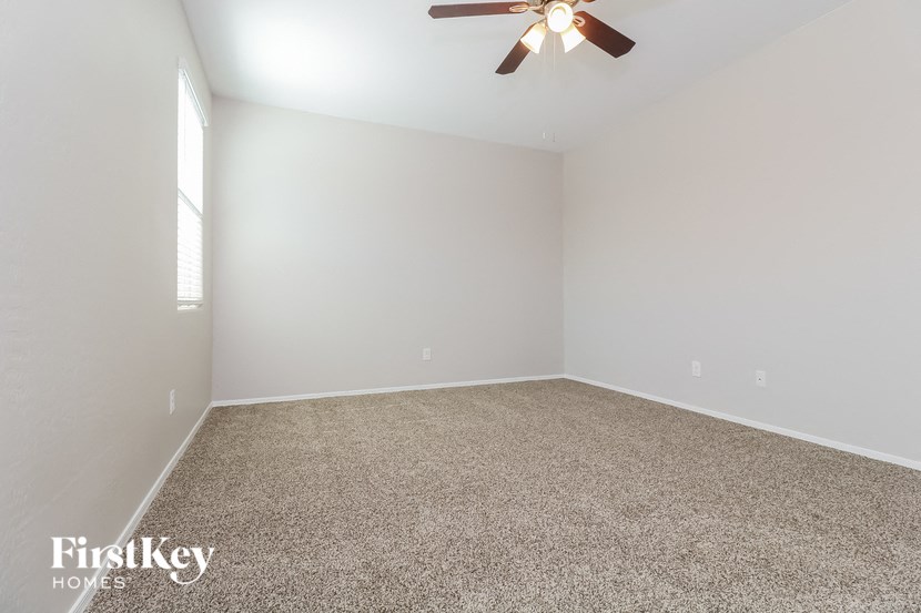 an empty living room with a ceiling fan