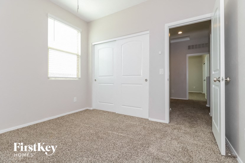 a bedroom with a white door and a hallway to a closet