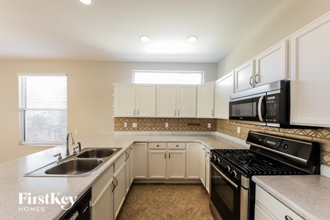 A kitchen with a black microwave above the stove.