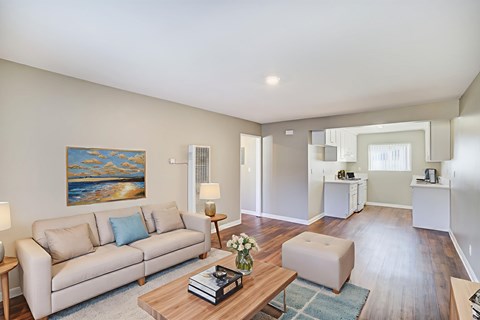 A living room with a couch, coffee table, and a painting on the wall.