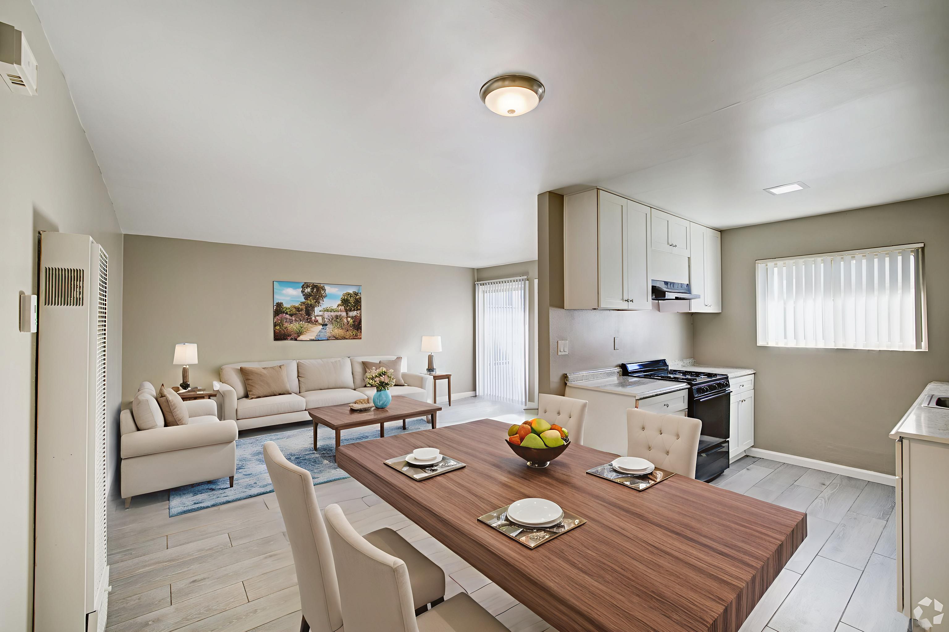 A modern dining room with a wooden table set for two.