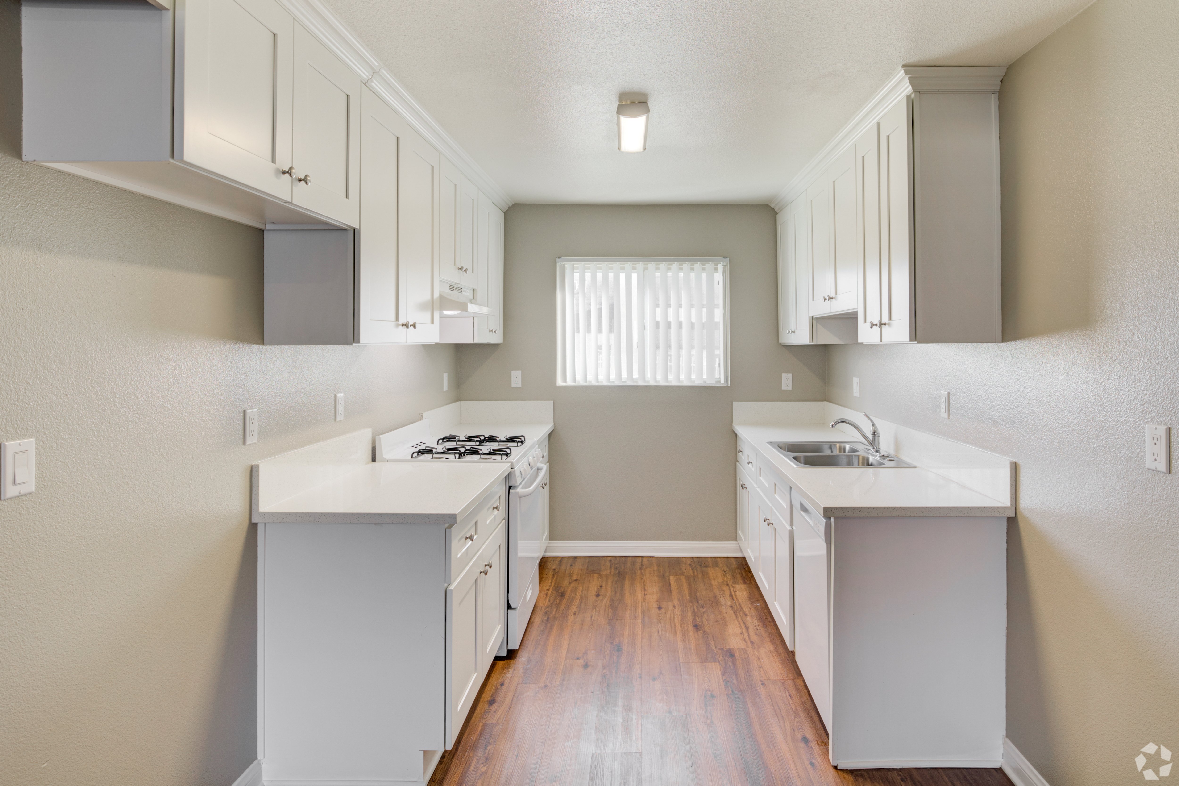 A kitchen with white appliances and cabinets.