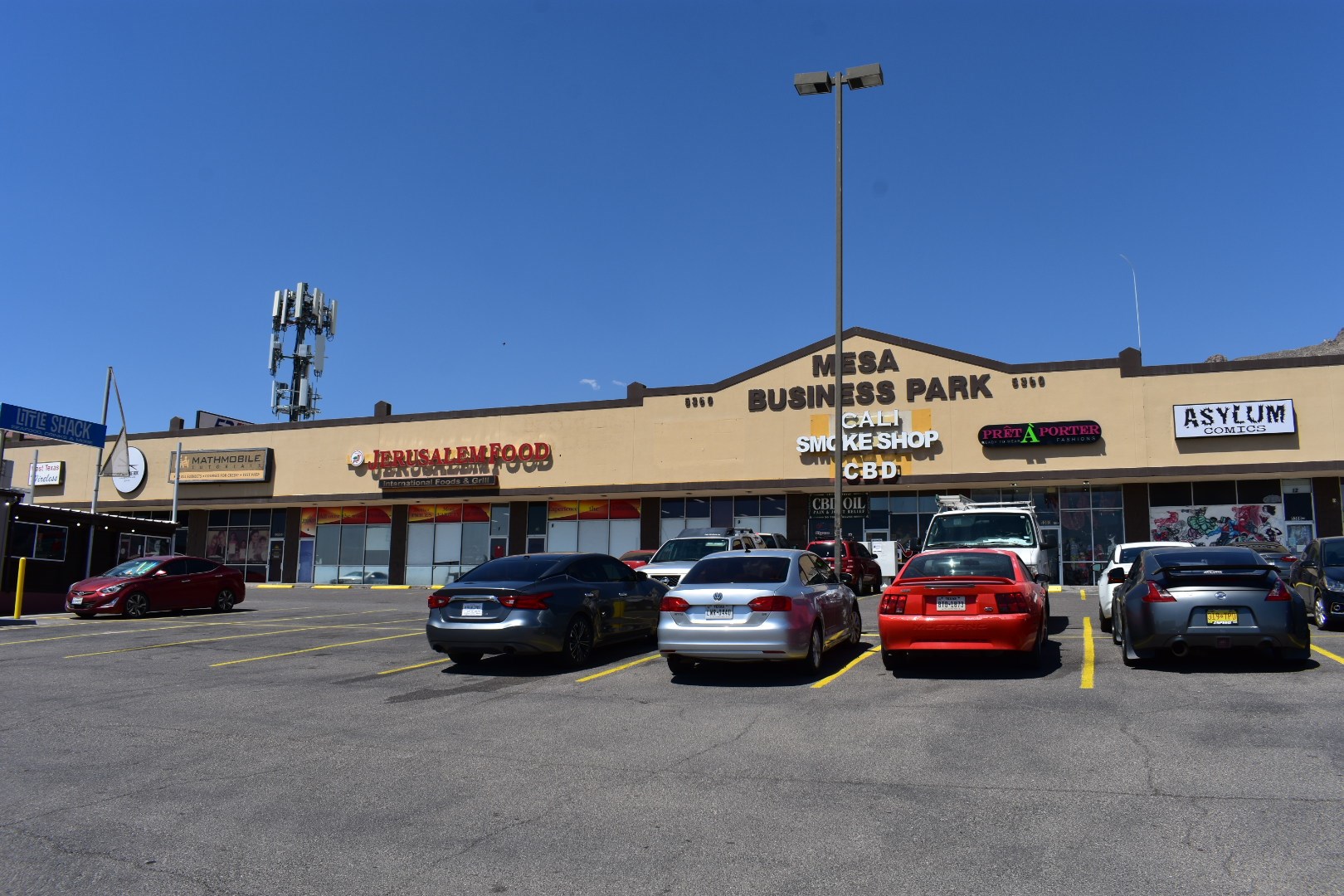 a parking lot filled with cars in front of a shopping mall
