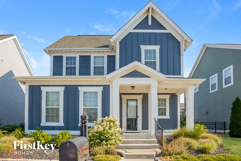 a blue house with a porch and a mailbox in front of it