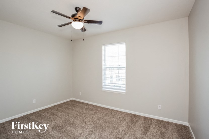 a bedroom with a ceiling fan and a window
