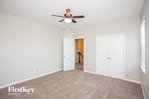 a living room with carpet and a ceiling fan
