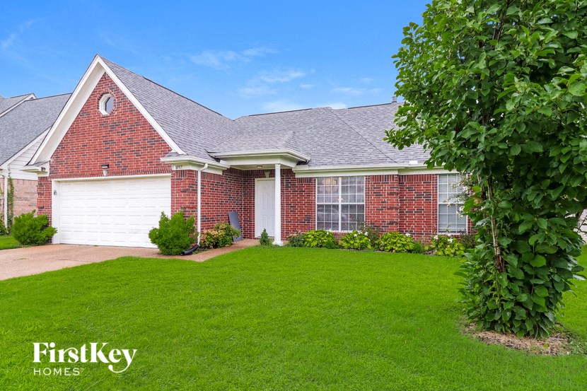 a brick house with a yard and a white garage door