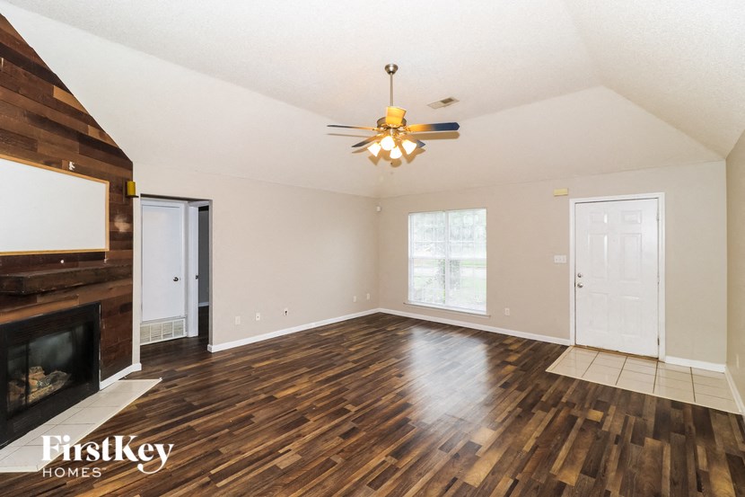 the living room with hardwood flooring and a ceiling fan