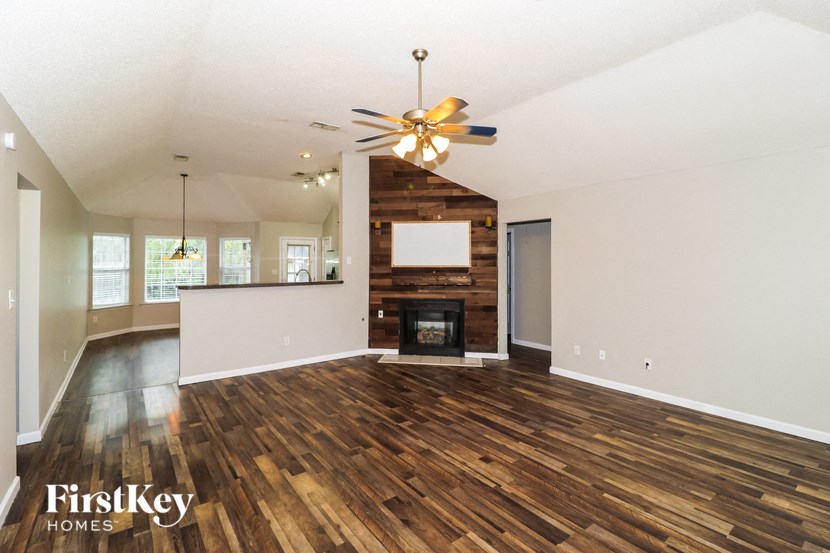the living room and dining room with wood flooring and a fireplace