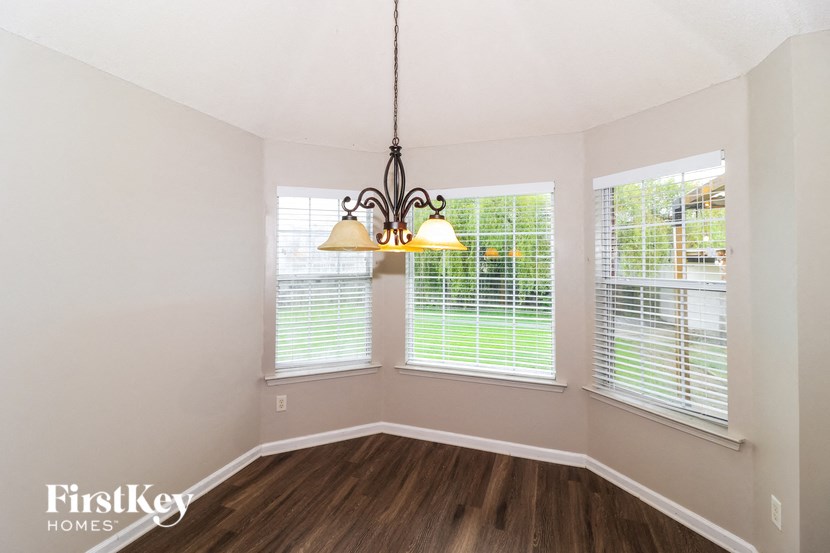 a living room with three windows and a chandelier