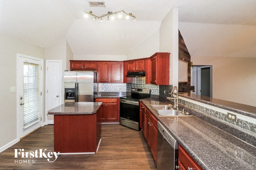 a kitchen with granite counter tops and wooden cabinets