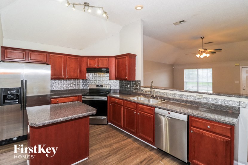 a kitchen with wooden cabinets and stainless steel appliances and granite counter tops