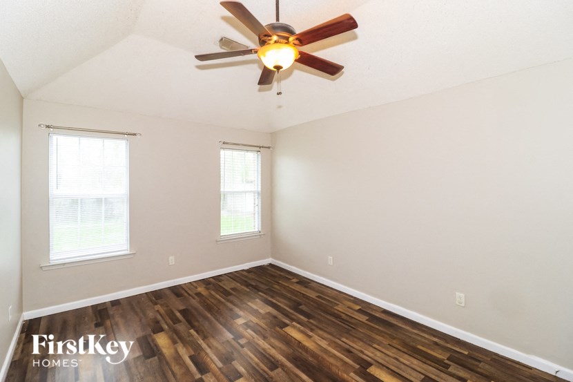 the living room of an empty house with a ceiling fan