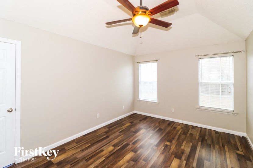 the living room with hardwood floors and a ceiling fan