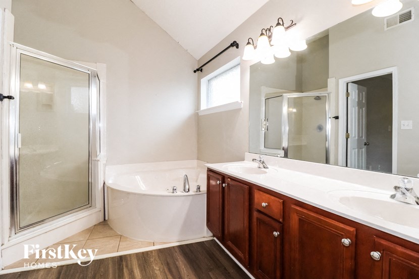 a bathroom with two sinks and a tub and a shower