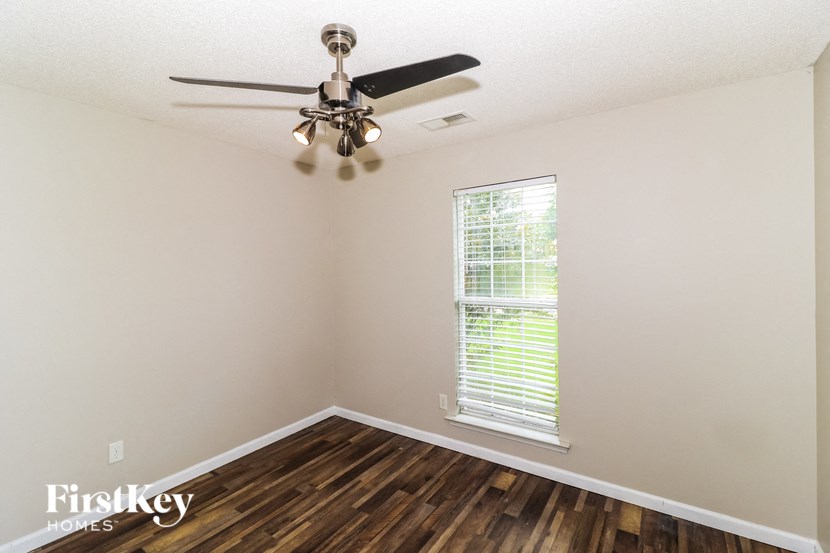 the living room of a home with a ceiling fan and a window