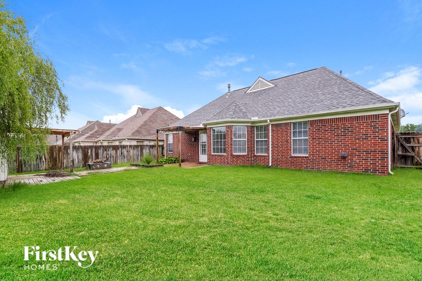a backyard with a brick house and a wooden fence