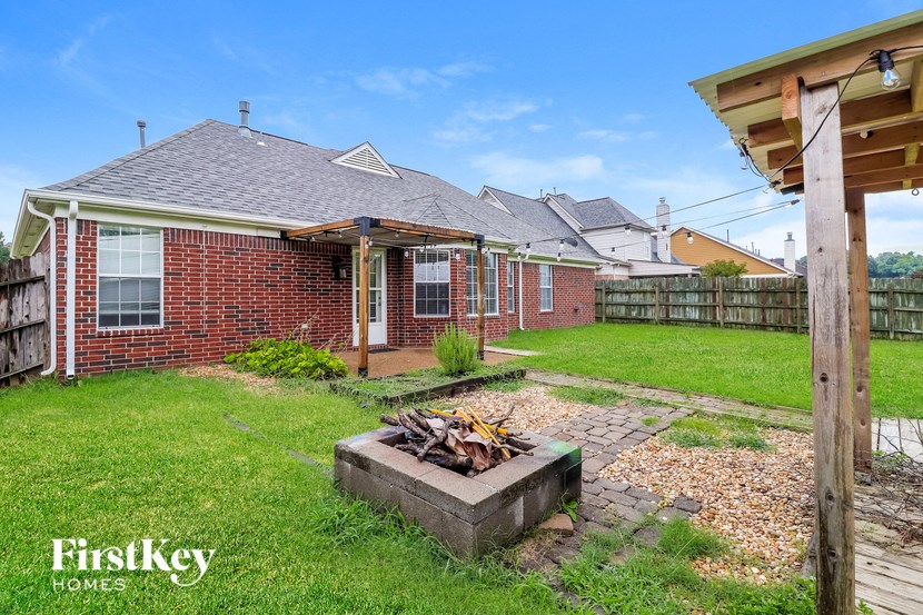 a backyard with a fire pit and a brick house
