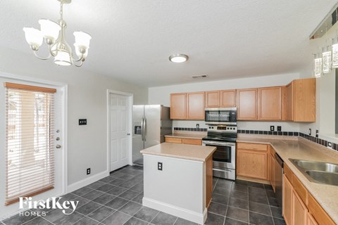 A kitchen with wooden cabinets and a white island.
