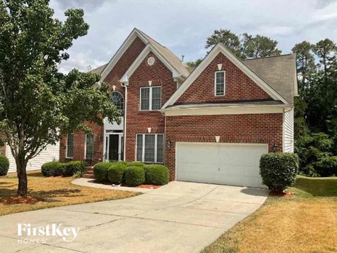 A brick house with a garage door is for sale.