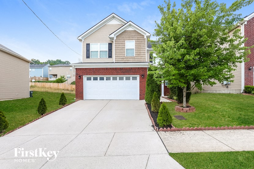a white garage door in front of a brick house