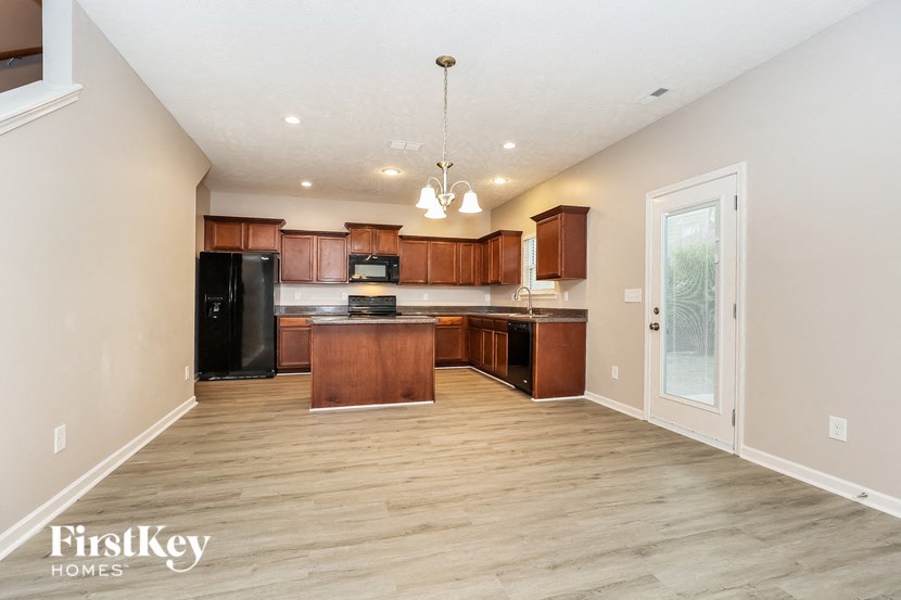 a large kitchen with wood flooring and black appliances