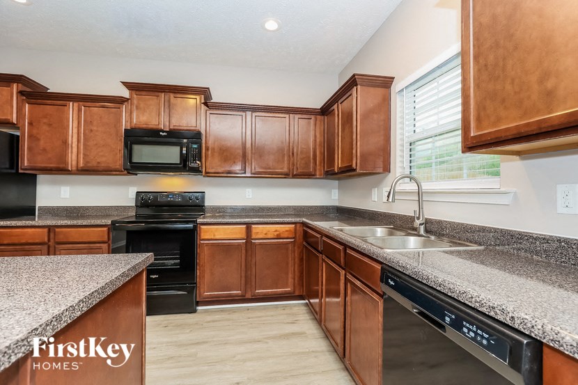 a kitchen with wood cabinets and granite counter tops and a sink