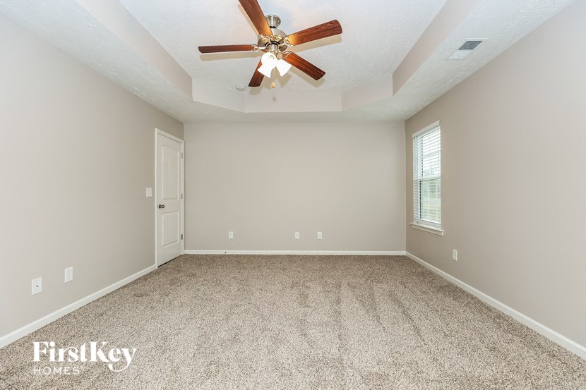 an empty room with a ceiling fan and a window