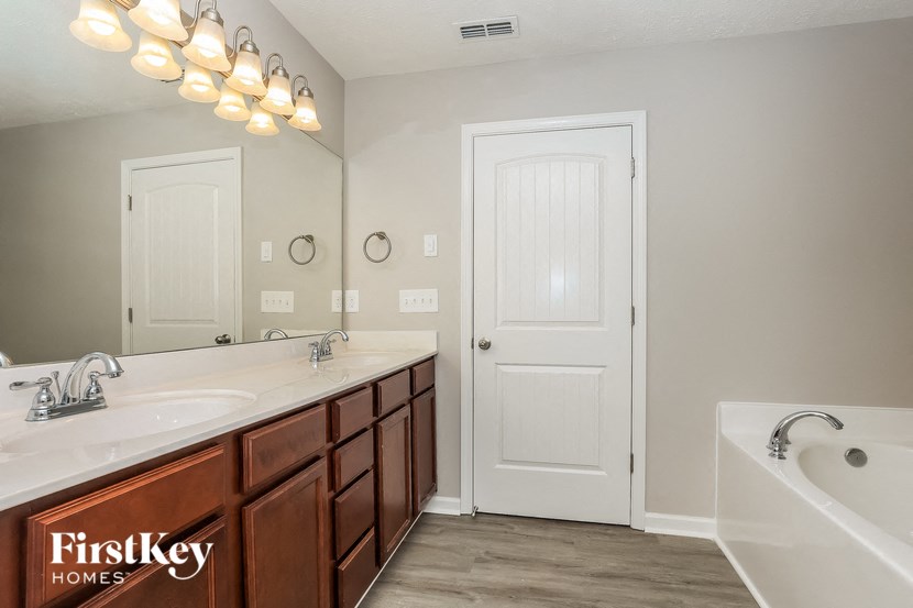 a bathroom with a tub and a sink and a mirror