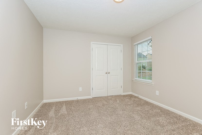 an empty bedroom with a door and a window