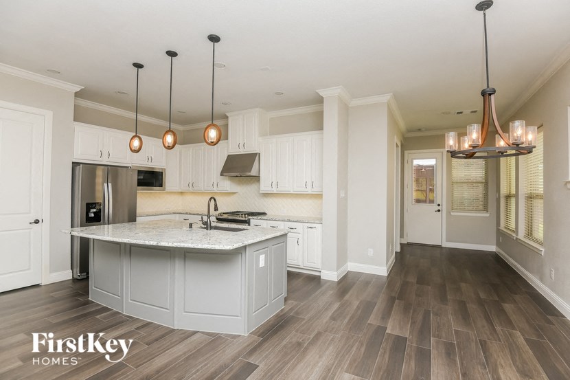 a kitchen with white cabinets and a marble counter top