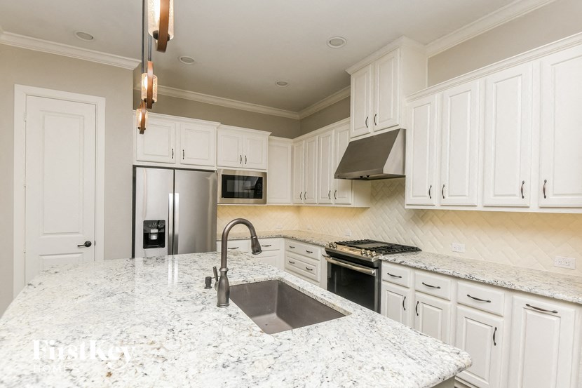 a large kitchen with white cabinets and a sink