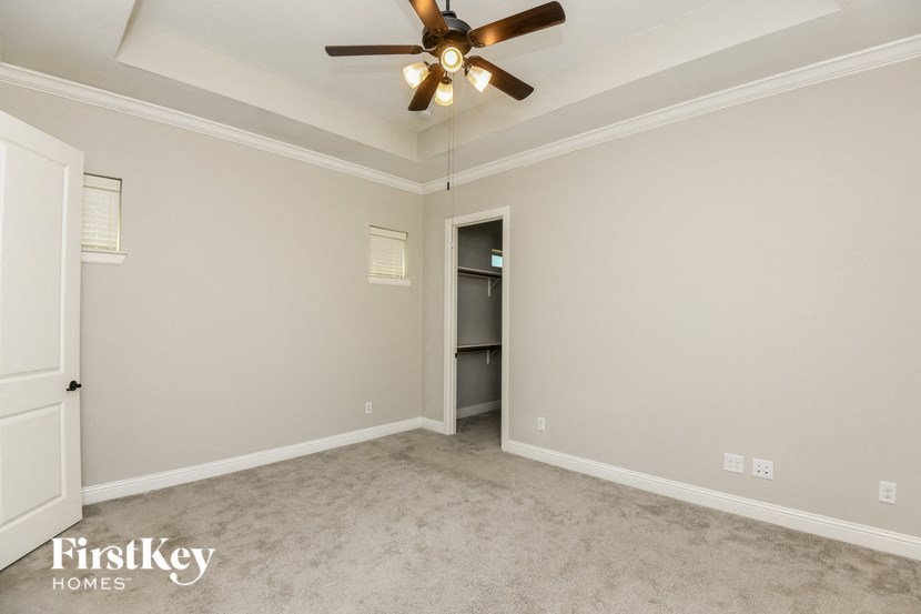 a empty room with a ceiling fan and a closet