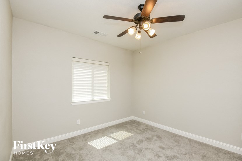a bedroom with a ceiling fan and a window