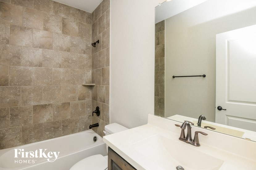 a bathroom with a sink toilet and tub and a mirror